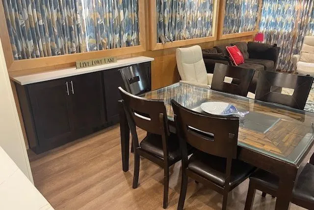 Slide: The Image of Dining area in 2003 Fantasy 18x80 Houseboat with glass table and wooden chairs. - 9