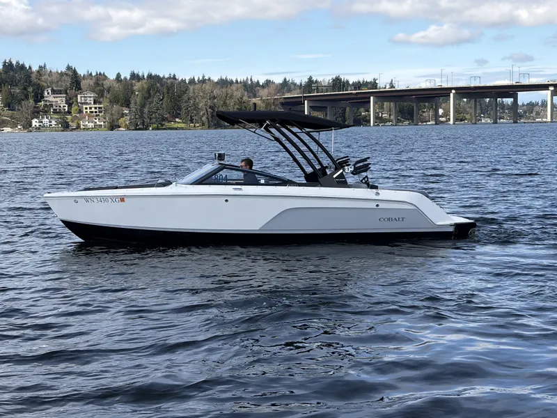Slide: The Image of 2025 Cobalt CS23 Surf boat on a serene lake. - 9