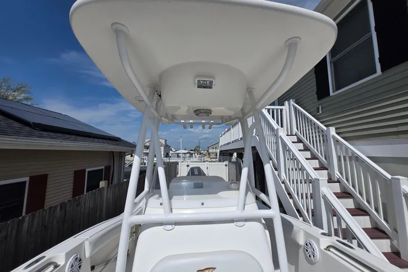 Slide: The Image of 2013 Tidewater 210 LXF boat with T-top, docked near residential area. - 11