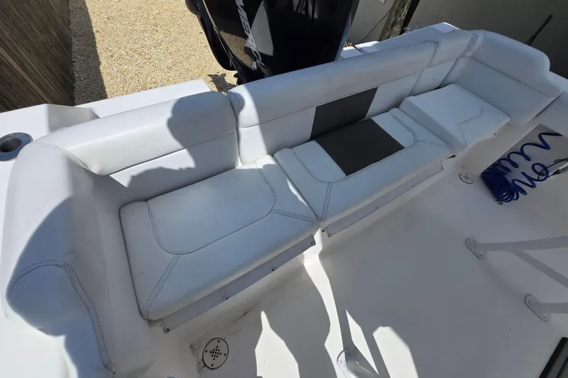 Slide: The Image of 2013 Tidewater 210 LXF boat interior seating with white upholstery and cup holder. - 14