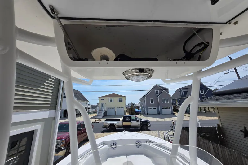 Slide: The Image of 2013 Tidewater 210 LXF boat with T-top, parked in residential area. - 19
