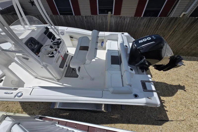 Slide: The Image of 2013 Tidewater 210 LXF boat with Mercury engine, featuring a sleek white interior and modern controls. - 3