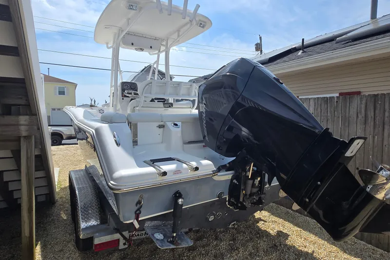 Slide: The Image of 2013 Tidewater 210 LXF boat on trailer, featuring powerful outboard motor. - 6