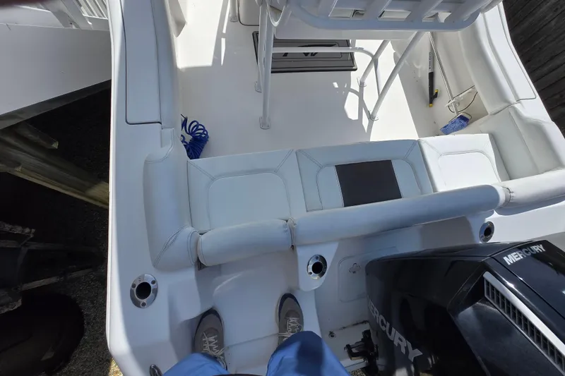 Slide: The Image of 2013 Tidewater 210 LXF boat interior with Mercury engine, white seating, and deck accessories. - 8
