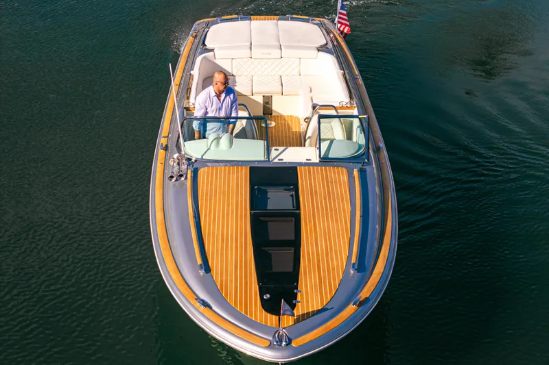 Slide: The Image of 2021 Chris-Craft Corsair 34 boat cruising on water, featuring elegant wooden deck design. - 10