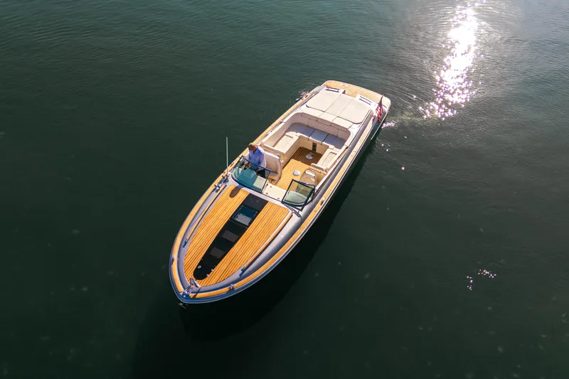 Slide: The Image of 2021 Chris-Craft Corsair 34 boat on calm water, sunlight reflecting on surface. - 12