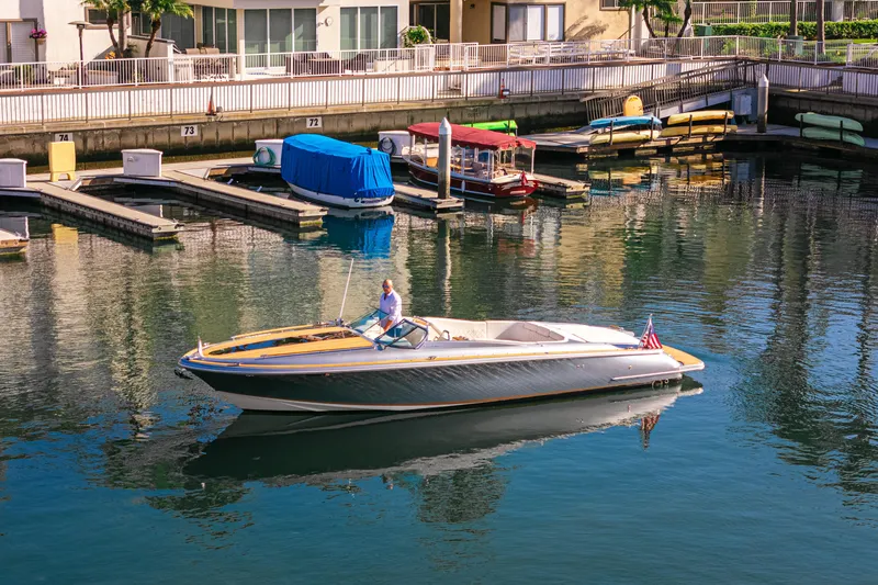 Slide: The Image of 2021 Chris-Craft Corsair 34 boat cruising in a marina with docked boats. - 4