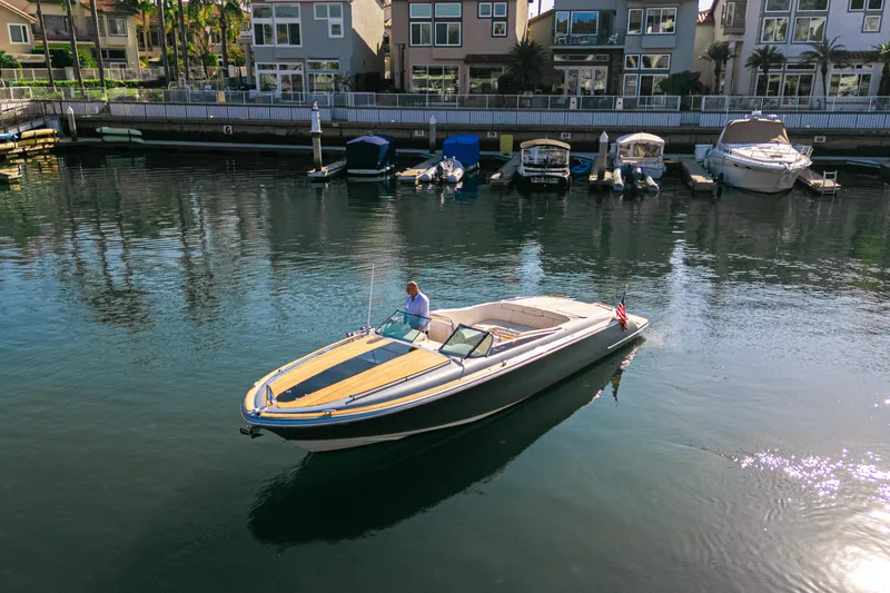 Slide: The Image of 2021 Chris-Craft Corsair 34 boat cruising in a serene marina setting. - 5