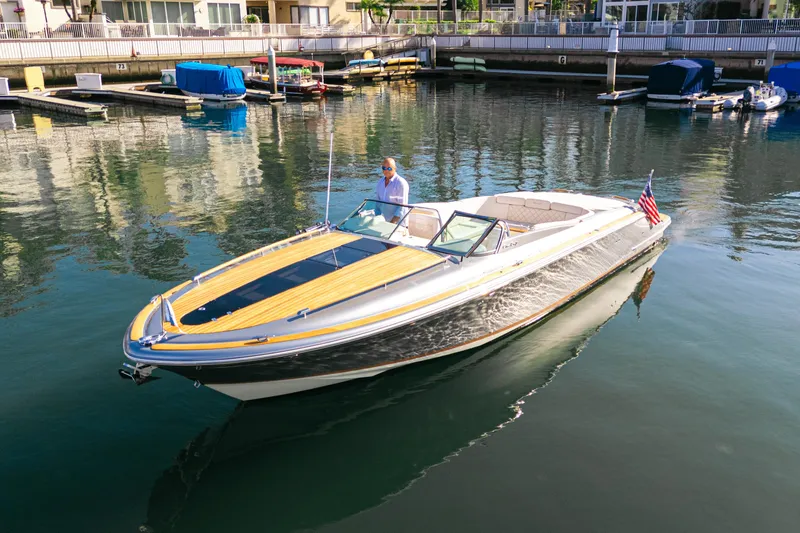 Slide: The Image of 2021 Chris-Craft Corsair 34 boat cruising in a marina with a person onboard. - 6