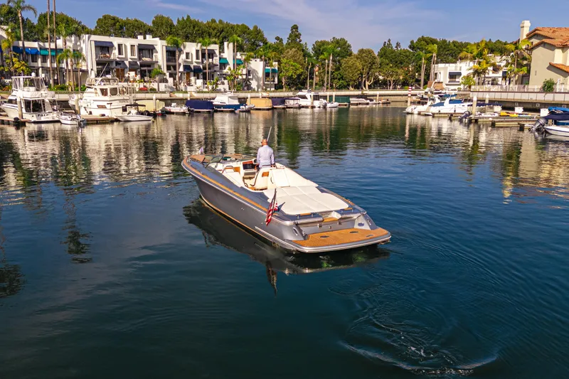 Slide: The Image of 2021 Chris-Craft Corsair 34 cruising in a marina with waterfront homes. - 7