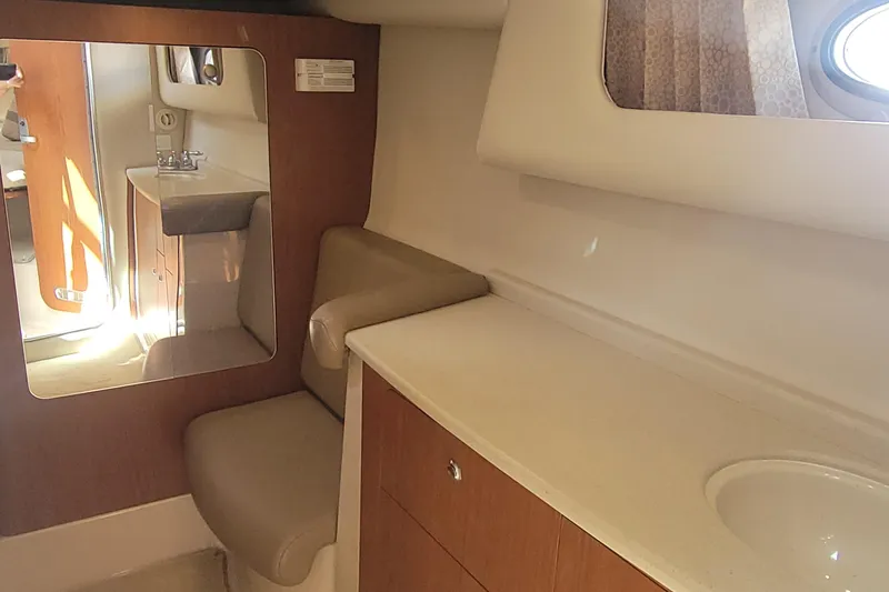 Slide: The Image of Interior of 2003 Chaparral 320 Signature mid cabin boat with mirror, sink, and seating area. - 11
