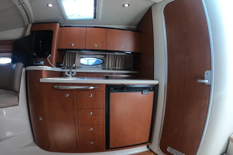 Slide: The Image of 2003 Chaparral 320 Signature yacht interior with wooden cabinetry and compact kitchenette. - 13
