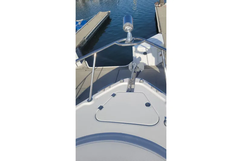 Slide: The Image of Bow view of 2003 Chaparral 320 Signature at dock, featuring anchor and railing. - 18