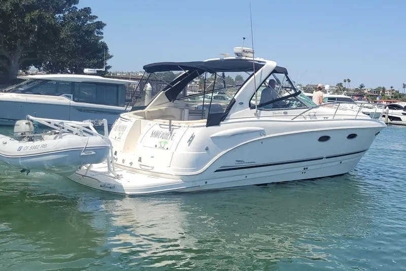 Slide: The Image of 2003 Chaparral 320 Signature boat Stern view in a marina with inflatable dinghy attached. - 2