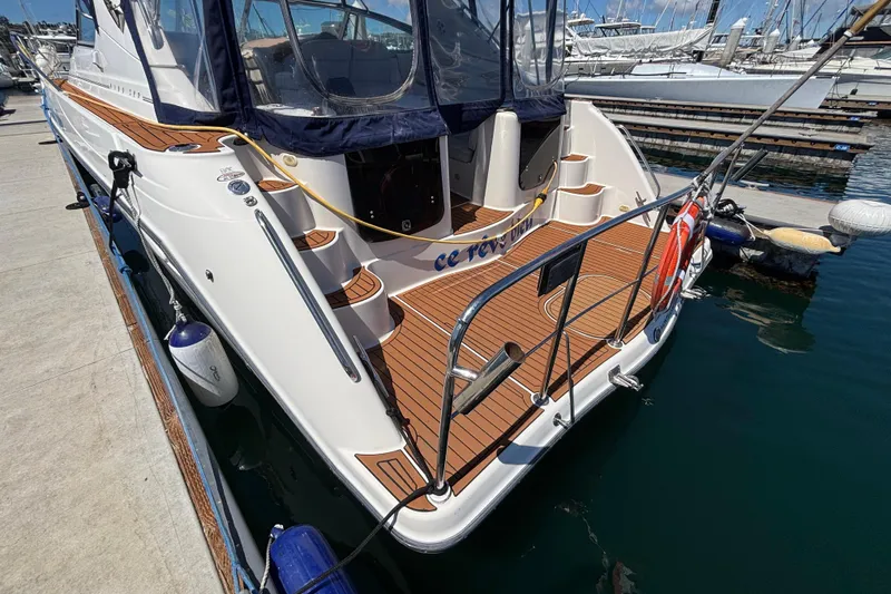 Slide: The Image of 1997 Maxum 4100 SCR yacht docked at marina, featuring sleek design and wooden deck. - 3