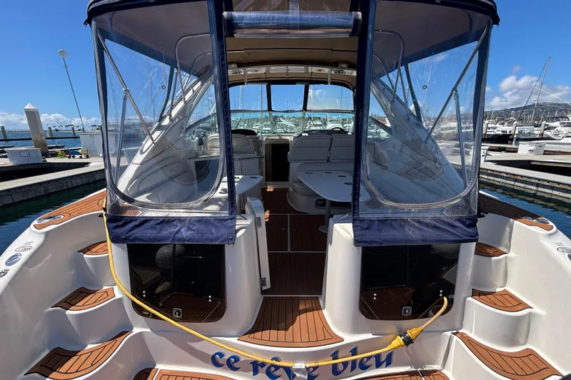 Slide: The Image of 1997 Maxum 4100 SCR yacht docked, featuring spacious deck and clear canopy. - 4