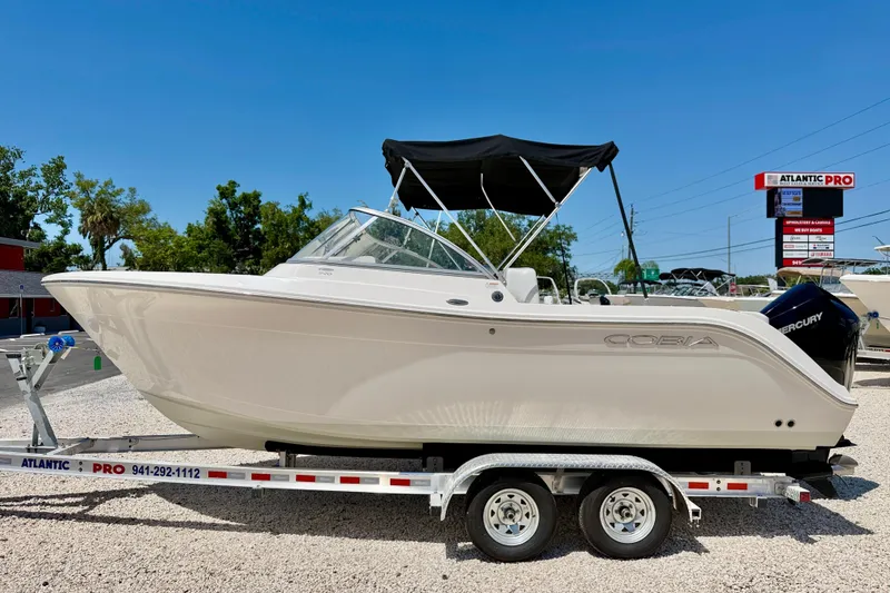 The Image of 2023 Cobia 220 Dual Console boat on trailer, outdoor display. - 0