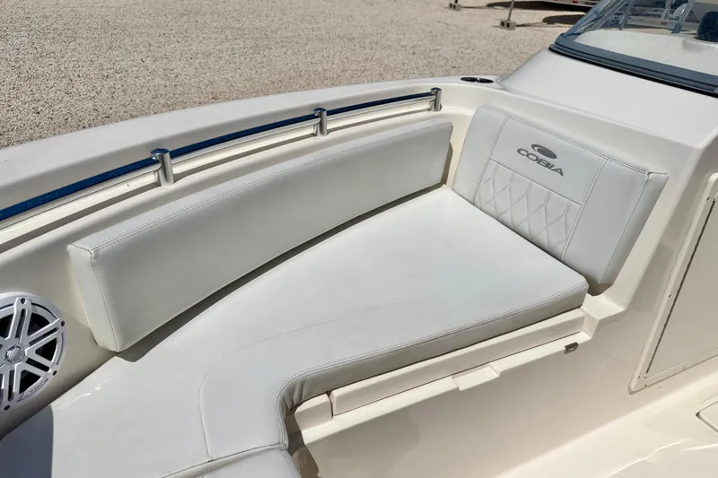 Slide: The Image of 2023 Cobia 220 Dual Console boat interior with white cushioned seating. - 10