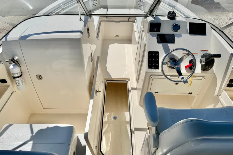Slide: The Image of 2023 Cobia 220 Dual Console boat interior with steering wheel and control panel. - 12