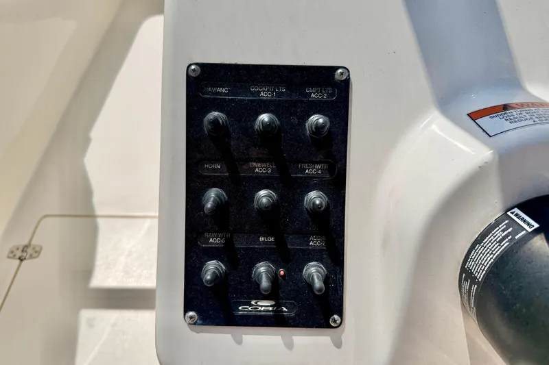 Slide: The Image of Control panel of 2023 Cobia 220 Dual Console boat with labeled switches. - 14