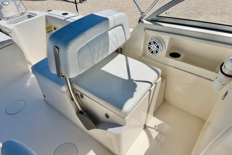 Slide: The Image of 2023 Cobia 220 Dual Console boat interior with cushioned seating and speaker. - 21
