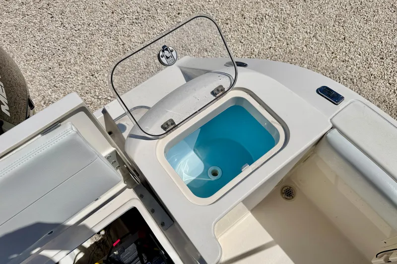 Slide: The Image of 2023 Cobia 220 Dual Console boat interior with open storage compartment. - 25