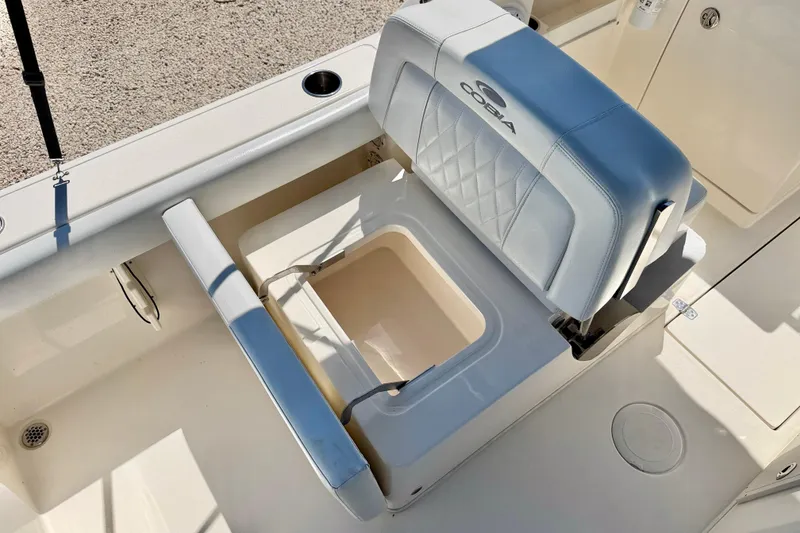 Slide: The Image of 2023 Cobia 220 Dual Console boat seat with storage compartment open. - 26