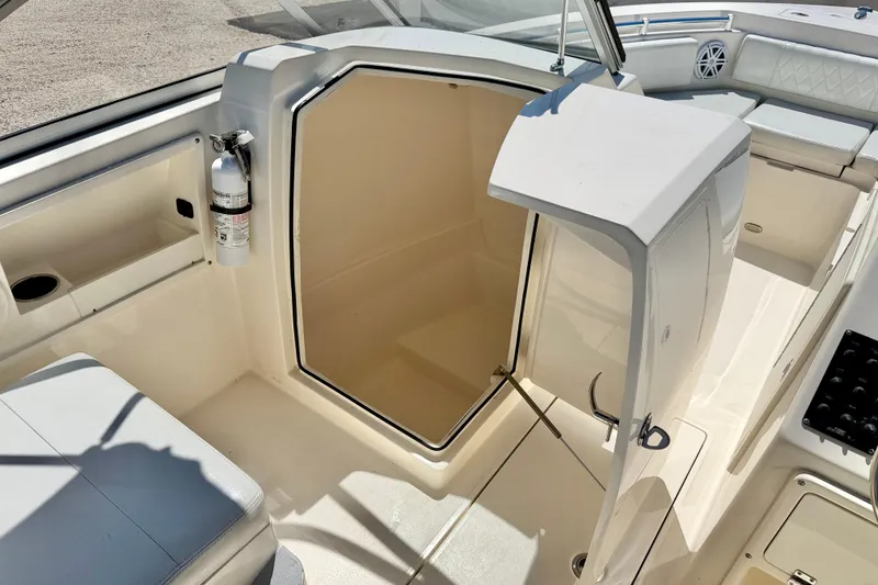 Slide: The Image of 2023 Cobia 220 Dual Console interior with seating, storage, and fire extinguisher. - 28