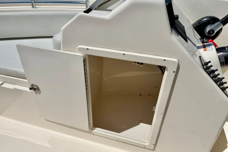 Slide: The Image of Open storage compartment on 2023 Cobia 220 Dual Console boat. - 30