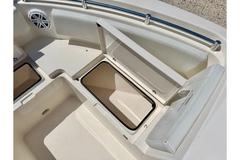 Slide: The Image of 2023 Cobia 220 Dual Console boat storage compartments and seating area. - 32