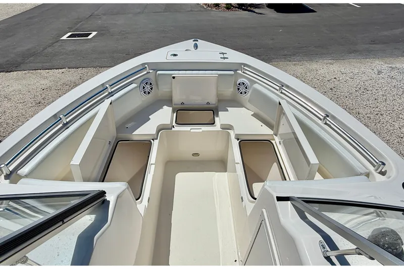 Slide: The Image of 2023 Cobia 220 Dual Console boat interior with open storage compartments and seating. - 34
