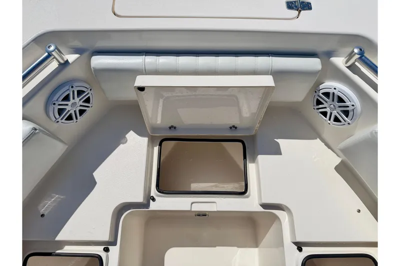 Slide: The Image of 2023 Cobia 220 Dual Console boat interior with storage compartments and speakers. - 36