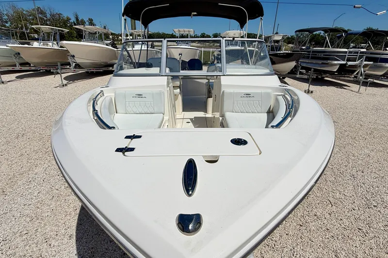 Slide: The Image of 2023 Cobia 220 Dual Console boat displayed in a sunny outdoor showroom. - 37