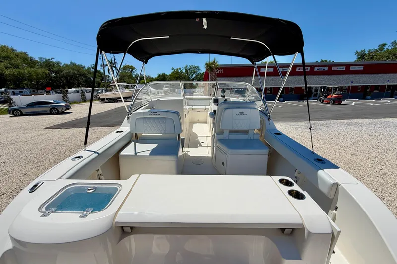 Slide: The Image of 2023 Cobia 220 Dual Console boat with seating and canopy in a parking lot. - 38