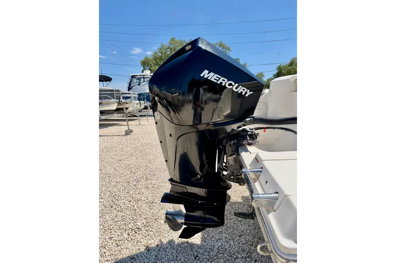 Slide: The Image of 2023 Cobia 220 Dual Console with Mercury outboard motor in a boatyard setting. - 39