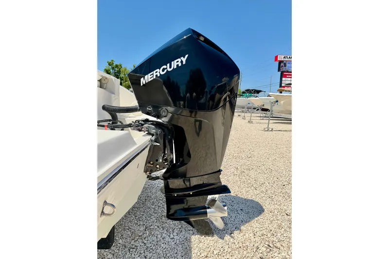 Slide: The Image of 2023 Cobia 220 Dual Console with Mercury outboard motor in a boat dealership. - 40