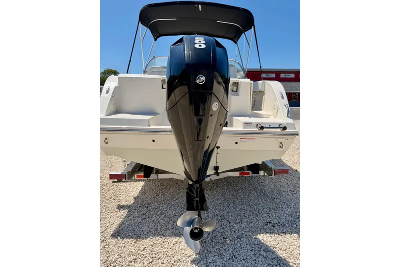 Slide: The Image of 2023 Cobia 220 Dual Console boat with outboard motor, parked on gravel. - 41
