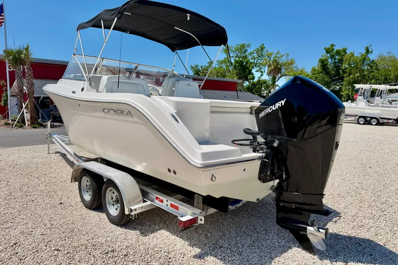 Slide: The Image of 2023 Cobia 220 Dual Console boat with Mercury engine on a trailer. - 7