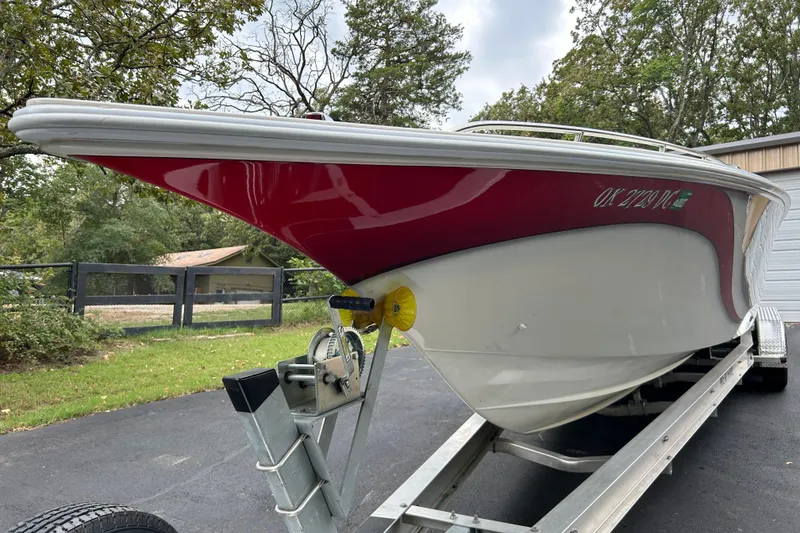 Slide: The Image of 2002 Fountain 38 Lightning boat on trailer, red and white hull, parked outdoors. - 10