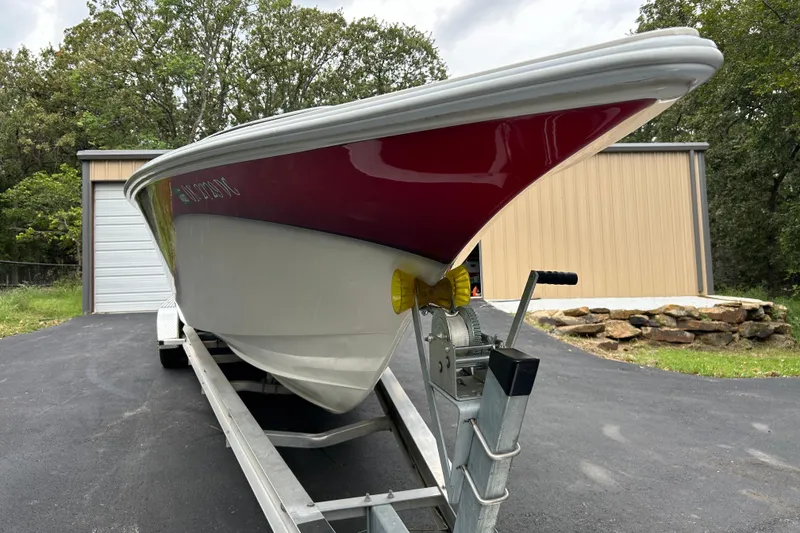 Slide: The Image of 2002 Fountain 38 Lightning boat on trailer, parked near a garage. - 11