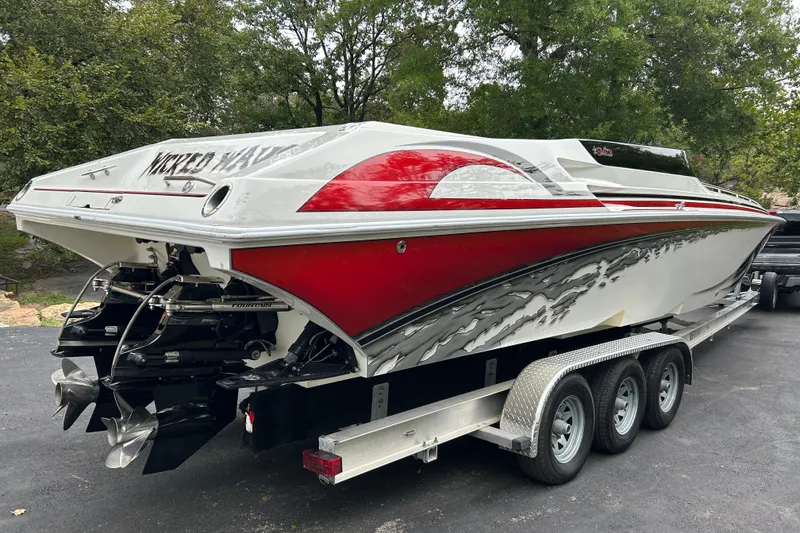 Slide: The Image of 2002 Fountain 38 Lightning speedboat on trailer, featuring red and white design. - 12