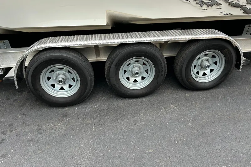 Slide: The Image of Triple-axle trailer for 2002 Fountain 38 Lightning boat on asphalt surface. - 13