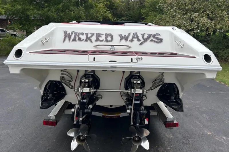 Slide: The Image of 2002 Fountain 38 Lightning boat with "Wicked Ways" text on the stern, parked outdoors. - 15