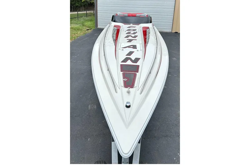 Slide: The Image of 2002 Fountain 38 Lightning speedboat with sleek white and red design, parked outdoors. - 16