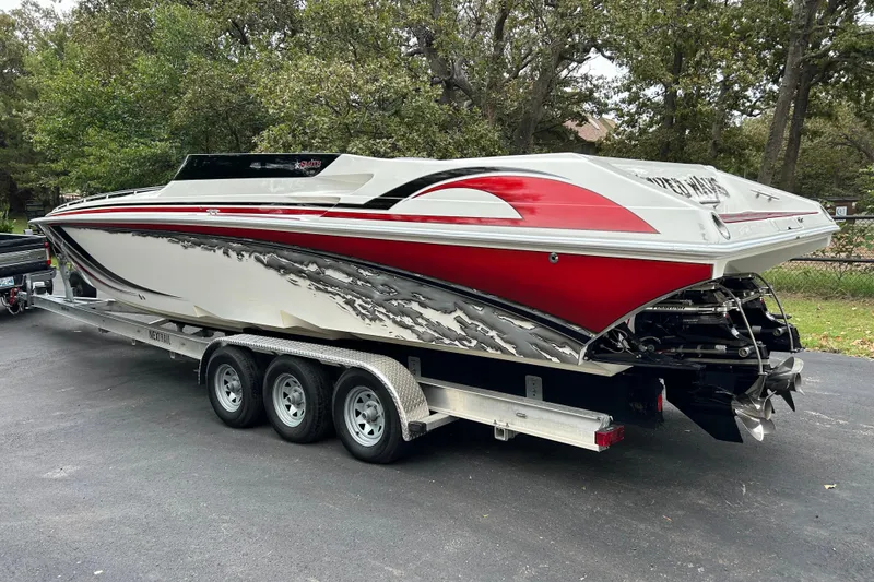 Slide: The Image of 2002 Fountain 38 Lightning speedboat with red and white design on a trailer. - 21