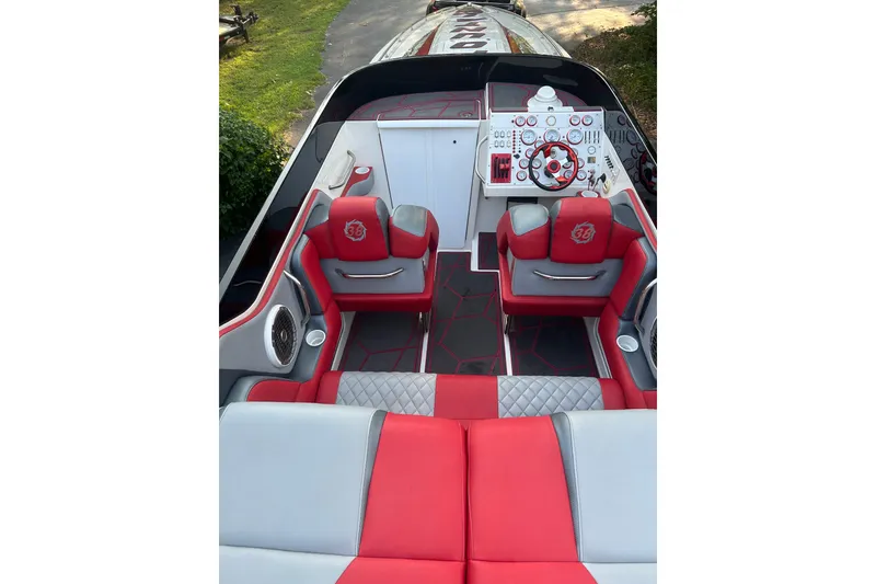 Slide: The Image of 2002 Fountain 38 Lightning boat interior with red and gray seating, modern dashboard, and steering wheel. - 28