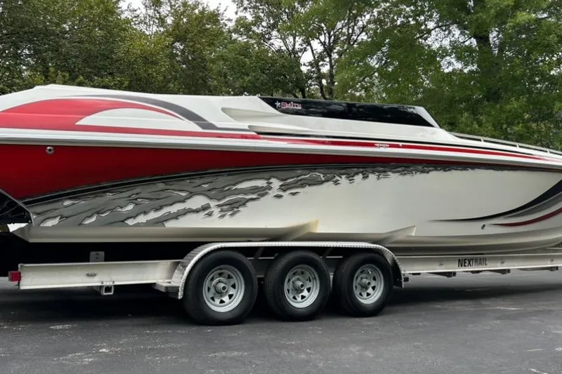 Slide: The Image of 2002 Fountain 38 Lightning boat on trailer, red and white design, parked outdoors. - 3