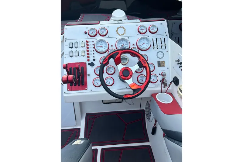 Slide: The Image of Dashboard of a 2002 Fountain 38 Lightning boat with red accents and gauges. - 30