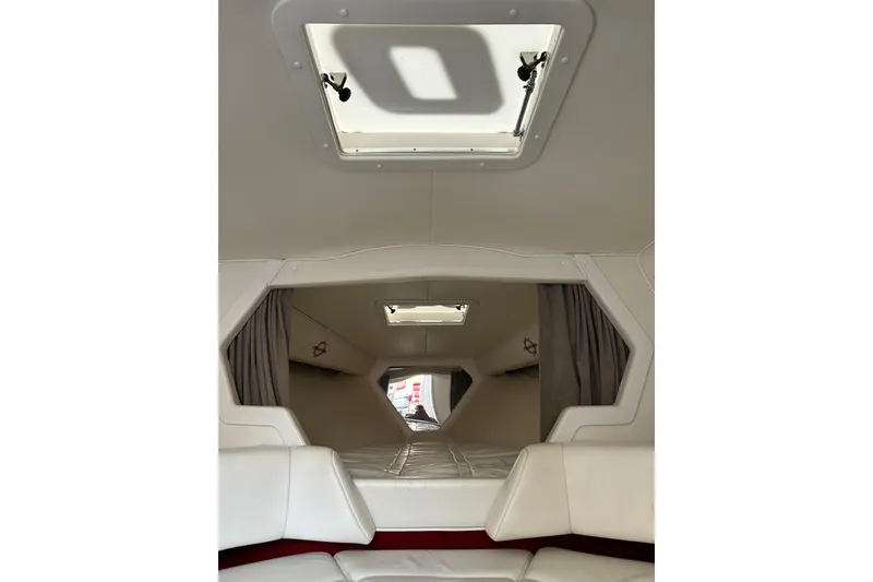 Slide: The Image of Interior cabin of a 2002 Fountain 38 Lightning boat, featuring white seating and a hatch. - 35