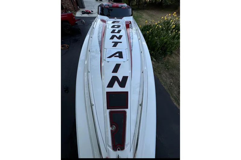 Slide: The Image of 2002 Fountain 38 Lightning speedboat with bold lettering on deck, parked outdoors. - 41
